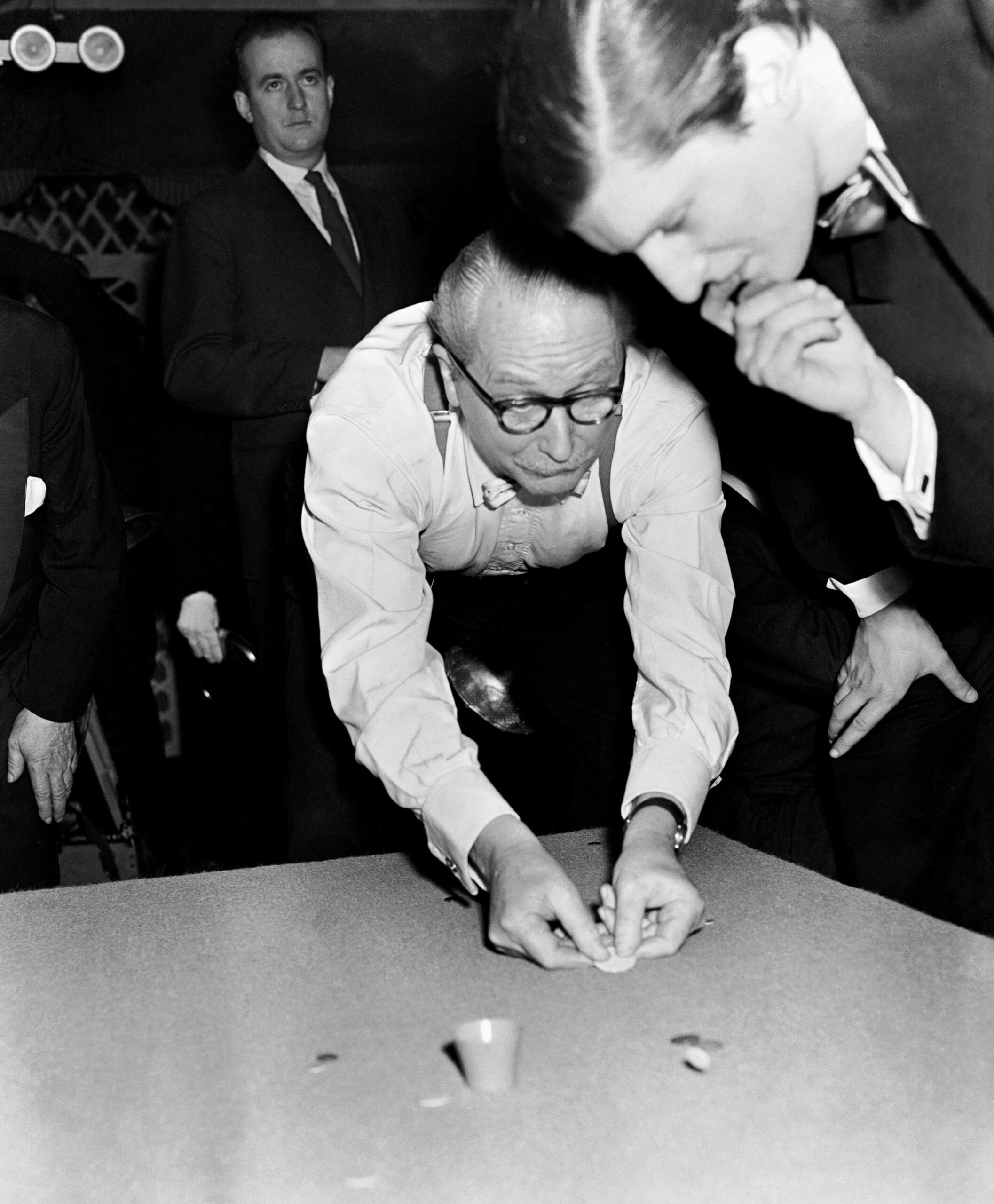 Tucker Tw ID • G4B6GW — AGPI ID • G4B6GW — publisher • www.alamy.com — title • Tiddlywinks - World Championship Tiddlywinks Match - Cambridge University v The Empress Club - Empress Club, London — notes • G4B6GW Tiddlywinks - World Championship Tiddlywinks Match - Cambridge University v The Empress Club - Empress Club, London — keywords • Sport, Unspecified, Sport, 301-archive-341296, s&gsportedit, game, playing, general, view, b/w, black, and, white, mangab, archivenewscansmay2011, Captain, of, the, Empress, Club, Sir, Hugh, Stockwell, with, jacket, off, uses, both, hands, to, squidge, his, wink, to, the, pot, while, anxiously, biting, his, finger, nail, is, his, partner, Lord, Valentine, Thynne